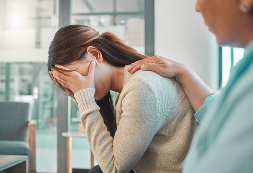 Woman crying as she is been consoled