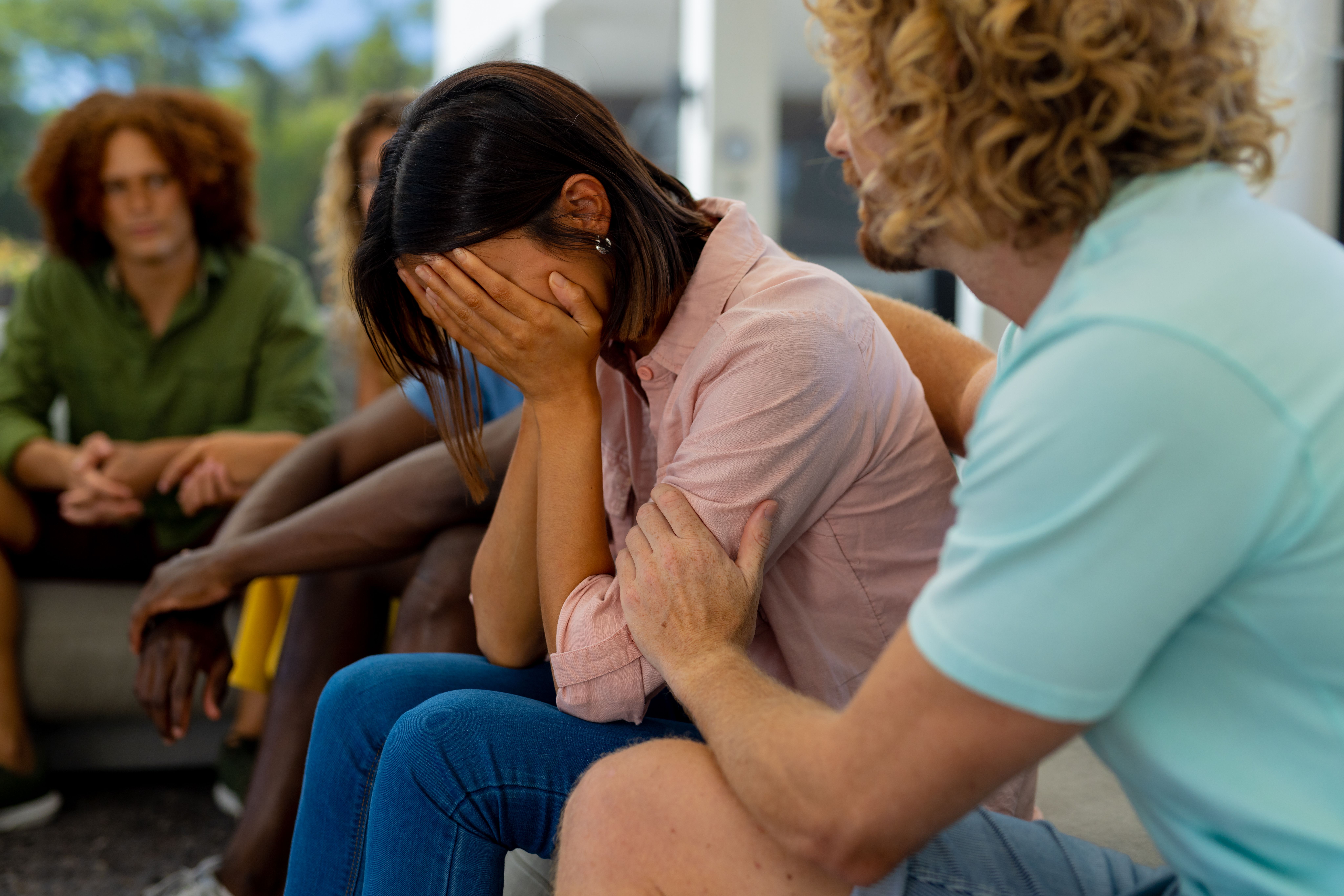 photo of woman sitting down and crying